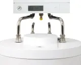 Nowoczesny piec gazowy kondensacyjny z cyfrowym wyświetlaczem i manometrem. Widoczne przyłącza hydrauliczne.