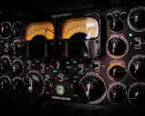 Panneau de compresseur mastering avec deux VU-mètres lumineux. Apprenez comment utiliser un compresseur en ajustant les nombreux boutons et sélecteurs.