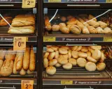 Różnorodne bułki i bagietki na półkach sklepowych. Idealne na śniadanie, choć warto sprawdzić ich kcal.