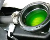 Líquido refrigerante verde brillante en el depósito del radiador, cerca de la junta culata. El aceite no se ve, pero el refrigerante es vital para el motor.