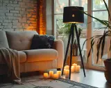 Przytulny salon z kanapą, dywanem i lampą stojącą chrom. Wokół lampy płoną świece, tworząc ciepłą atmosferę.