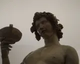 Bacchus, jeune dieu du vin, couronné de grappes, tient une coupe. Une œuvre d'art inspirée par Michel-Ange.