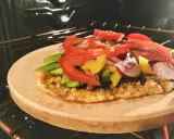 Pizza na kamieniu w piekarniku, z pomidorami, papryką i cebulą. Po pieczeniu dowiedz się, jak umyć kamień do pizzy.