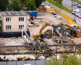 Dwa koparki pracują przy wyburzaniu budynku. Szacowany koszt wyburzenia domu 100m2 może być wysoki.