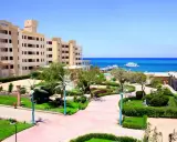 Piękny widok na **King Tut Resort** z basenem, palmami i morzem w tle.