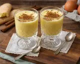 Zwei Gläser cremiger Zabaione, bestreut mit Zimt. Dazu Savoiardi-Kekse und Zimtstangen – ein perfektes Zabaione Rezept.