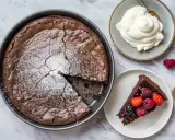En saftig kladdkaka med pudersocker, serverad med vispad grädde och färska bär. Ett perfekt kladdkaka recept för alla chokladälskare.