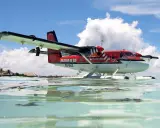 Ein rotes Twin Otter Flugzeug schwimmt auf dem Wasser vor den Malediven.