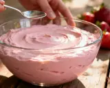 Bol de crème de fraises et mascarpone, avec des fraises fraîches sur le côté.