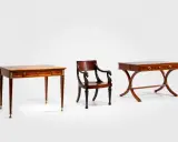 Trois meubles en bois sombre, dont deux tables fines et une chaise ornée de têtes de cygne, évoquant le style Louis XV.