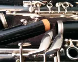 Détail d'une clarinette démontée, prête pour apprendre à jouer de cet instrument. Les clés argentées brillent.