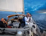 Leon Schulz und ein Kollege filmen auf See. Die Segel sind gesetzt, die Wellen schlagen gegen das Boot.