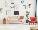 Sofa w kolorze ecru, jaki to kolor! Miękkie poduszki i narzuta dodają przytulności. Obok stoi fotel w intensywnym kolorze.