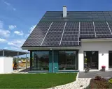 Ein modernes, energieautarkes Haus mit Solarmodulen auf dem Dach und einer Photovoltaik-Anlage auf dem Carport.