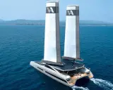 Le catamaran de luxe MODX 70 navigue sur une mer bleue, ses deux voiles imposantes portant le logo "A".