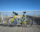 Bicicletta gialla pronta per un giro a Rimini Cattolica, con il mare e la spiaggia sullo sfondo.