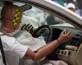 Maniquí en un coche, con el airbag desplegado. El airbag, entre otras funciones, protege de impactos.