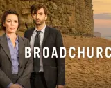 Två poliser står på en strand framför en klippa. Serien Broadchurch är en av de bästa kriminalserier topplista.