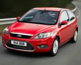 Czerwony Ford Focus MK2 1.6 benzyna w wersji 3-drzwiowej, jadący po zakręcie drogi.