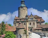 Zamek Czocha, z jego wieżą i kamiennymi murami, kryje wiele ciekawostek. Wspaniała budowla na tle błękitnego nieba.