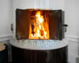 En öppen kamin med flammande ved. Det kan vara farligt att elda i kamin om man inte är försiktig.