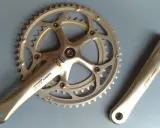 Srebrna korba rowerowa Shimano 105 z technologią Hollowtech 1 i zębatkami.