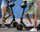 Apprenez comment utiliser une trottinette électrique pour vos déplacements urbains. Deux personnes se tiennent prêtes à partir.