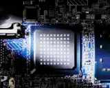 Gros plan sur un processeur d'ordinateur, montrant sa grille de contacts et les circuits imprimés environnants. Le nombre de cœurs du processeur est caché sous cette surface complexe.