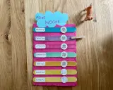 Montessori-Tafel zum Wochentage lernen. Bunte Holzstäbchen mit den Tagen der Woche und Symbolen.