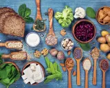 Różnorodne produkty bogate w białko dla wegetarian: tofu, soczewica, fasola, orzechy, nasiona, płatki owsiane, ryż, chleb pełnoziarnisty, jogurt, szpinak, brokuły, kalafior.