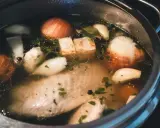 Szybkowar z bulionem: kawałki mięsa, cebula, czosnek, ziele angielskie i natka pietruszki tworzą aromatyczny rosół.