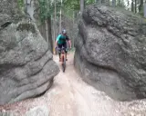 Rowerzysta pokonuje wąską ścieżkę między głazami na trasie w okolicach Lubania.