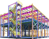 Estructura metálica tridimensional, mostrando la complejidad de la ingeniería estructural con vigas, columnas y escaleras de acceso en diversos colores.