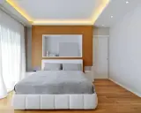 Illuminazione a scomparsa nel controsoffitto, un'idea moderna per un soffitto elegante. Camera da letto minimalista con letto bianco e testiera in legno.