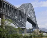 El **Puente de las Américas** cruza el Canal de Panamá, una imponente estructura de acero gris con un arco majestuoso.