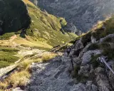 Turysta pokonuje kamienisty szlak z łańcuchami. Czy szlak na Giewont jest trudny? Ten odcinek wymaga ostrożności i dobrej kondycji.