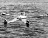 Tage Erlander, statsminister, flyter avslappnat på rygg i vattnet, med armarna utsträckta.