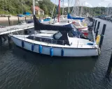 Voilier blanc amarré, prêt pour l'aventure. Un Dufour 1800, parfait pour une escapade en mer.