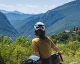 Rowerzysta podziwia malownicze góry między Francją a Hiszpanią. W oddali widać domy na zboczu.