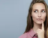 Nachdenkliche Frau mit langen Haaren, die über die Vorteile von Keratin und Kreatin für die Haargesundheit sinniert.
