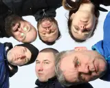 Grupa ludzi, w tym jeden z okularami, tworzy afro kolektyw. Wszyscy patrzą w obiektyw, tworząc ciekawe ujęcie.