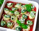 Zucchini-Cannelloni mit Ricotta-Spinat-Füllung in Tomatensauce, garniert mit frischem Basilikum.