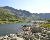 Kamieniste wybrzeże jeziora w Tatrach, idealne na wędrówkę szlakami turystycznymi Zakopane.