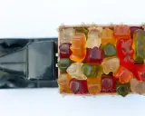 Un camión de juguete transporta una caja llena de gominolas de colores. ¡Cuidado, las gominolas caducan!