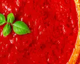 San Marzano Tomatensoße, perfekt für jedes Rezept. Ein Hauch frisches Basilikum rundet das Bild ab.