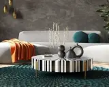 Nowoczesny salon w stylu feng shui z szarą kanapą, pomarańczowym kocem, czarno-białym stolikiem i turkusową podłogą.