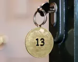 Klucz z okrągłą zawieszką z numerem 13 włożony do zamka.