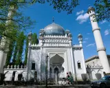 Weiße Moschee mit Kuppel und Minaretten, ein Beispiel für orientalische Architektur, im Sonnenschein.