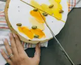 Delikatny tort z pistacjami i żółtym kremem, pokazany w momencie, jak kroić tort.
