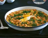 Un plato humeante de garbanzos con espinacas y huevo duro, una de las muchas deliciosas recetas con garbanzos.